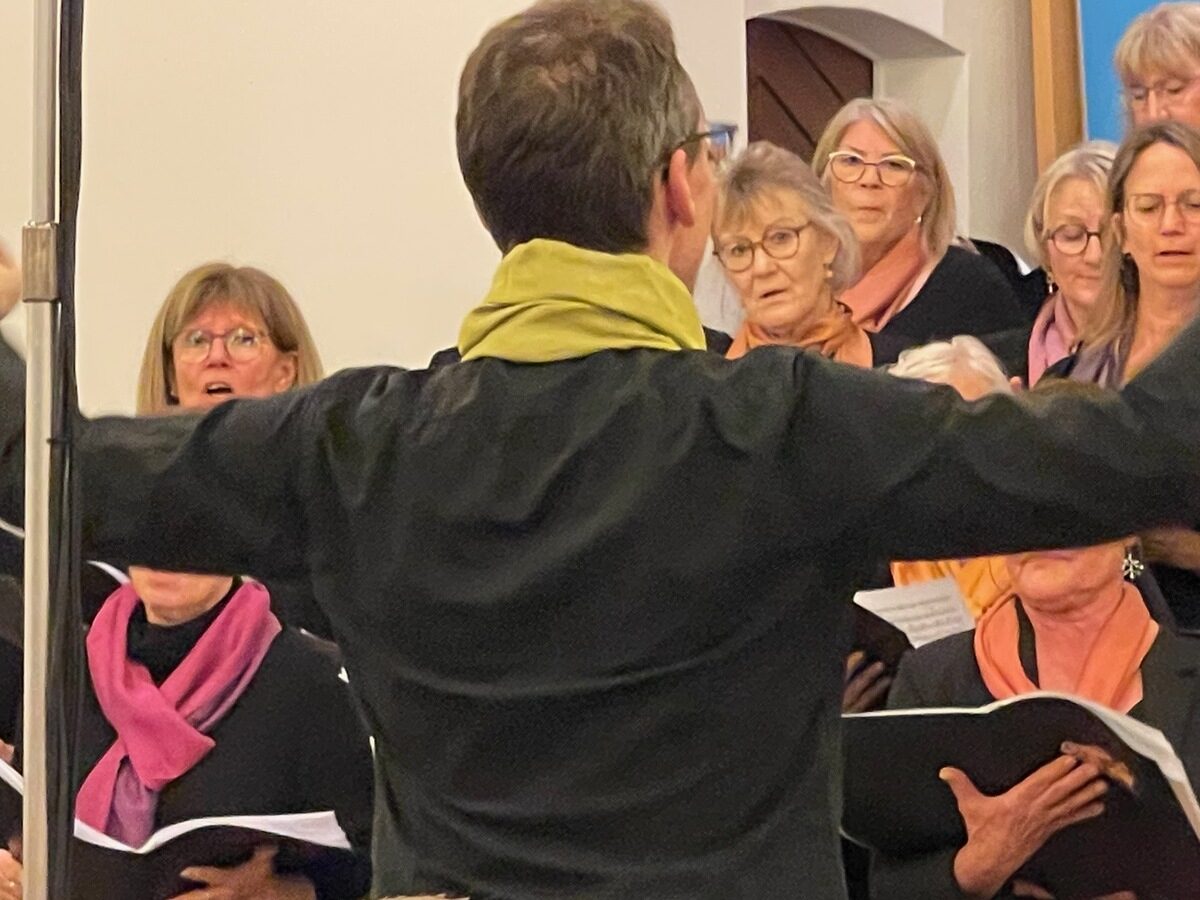 Matthias Zuppinger mit ausgebreiteten Armen vor dem Chor